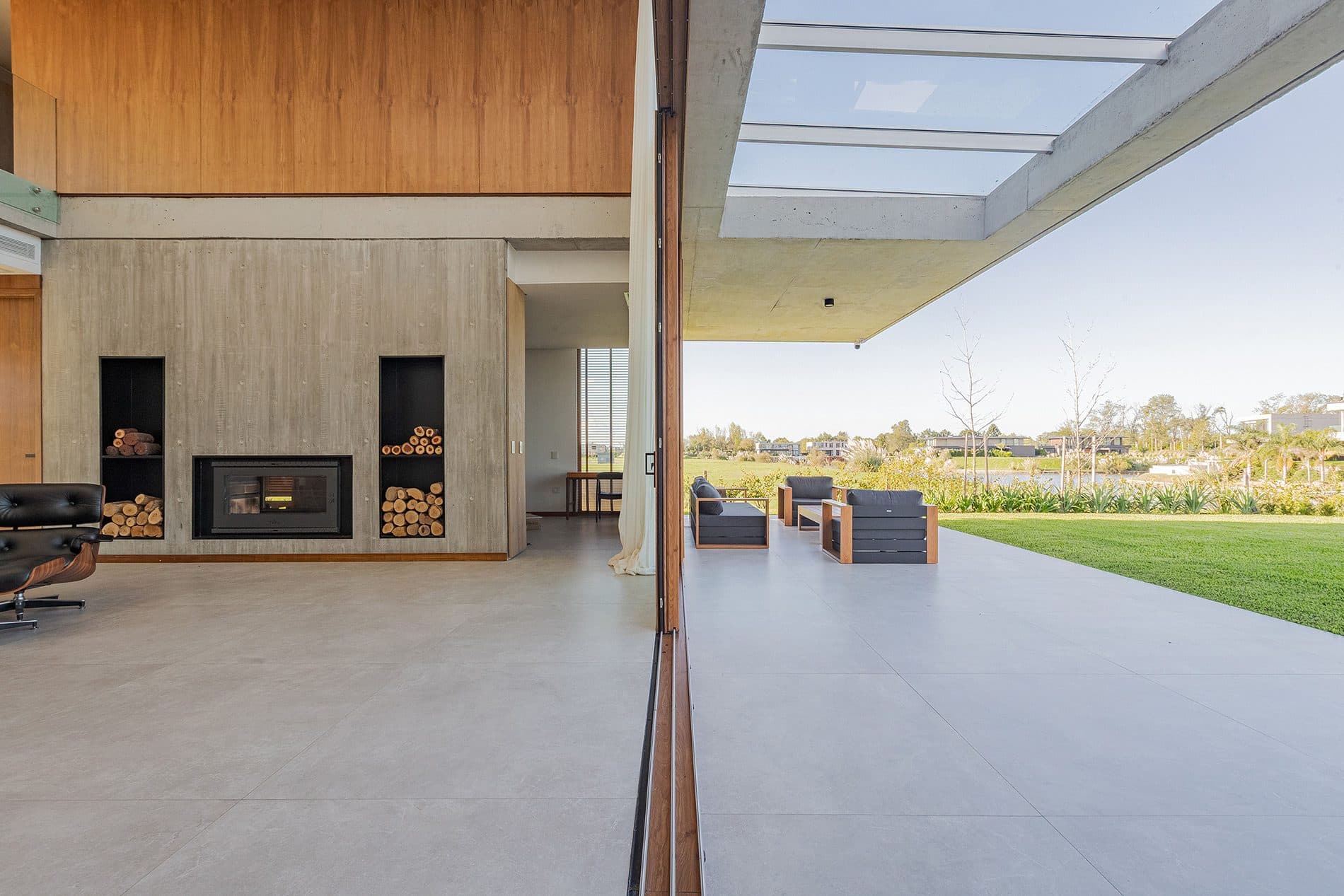 Open gallery with a timber table, fireplace and view of the garden